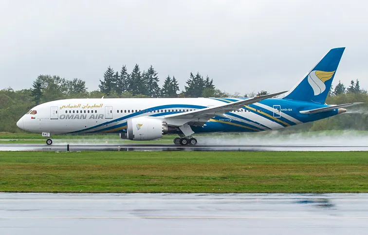 Самолет Oman Air на фоне живописного пейзажа Омана.